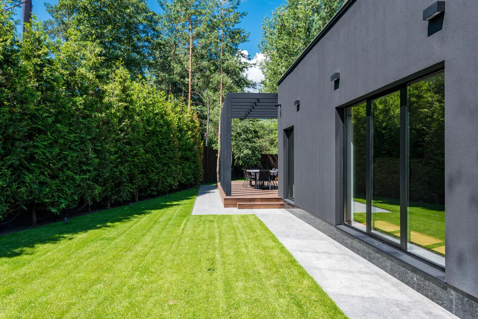 Moderne Gartenanlage mit Rasen, Terrasse und Pergola